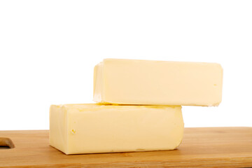 Two pieces of butter on a bamboo kitchen board, close-up, isolated on white background.