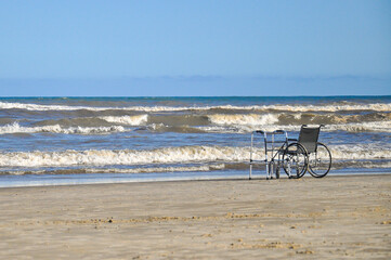 A walker and a wheelchair on the beach in a sunny day. Arroio do Sal, Rio Grande do Sul, Brazil