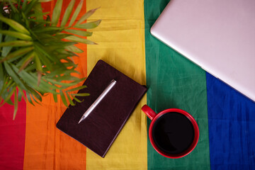 Items on the table. Morning coffee and protection of rights. Gay flag.	