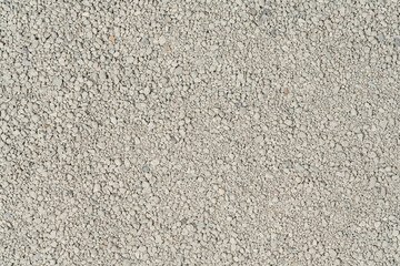 Small rocks ground texture background. white road stone. gravel pebbles stone texture. crushed granite. close up. grey clumping clay. cat litter