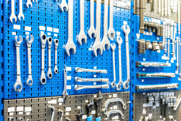 Many type and various metal wrench such as combination spanner and adjustable wrench etc. hanging on storage board