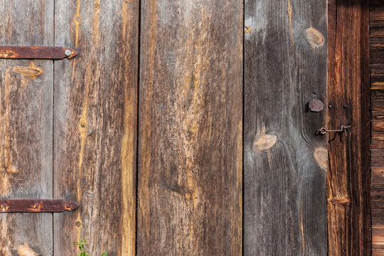 Rusty door hinges and metal latch on the wooden door of the barn