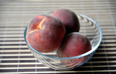 Red and yellow peach in a glass bowl