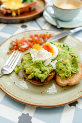 Avocado Toast with Poached Eggs and Tomatoes. Brunch plate. 