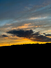 Orange sunset with purple cloud in the landscape, black silhouette of the windmills