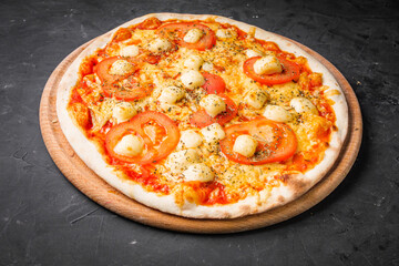 hot delicious traditional italian pizza on a dark stone background