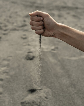 Man pouring sand through hand in desert