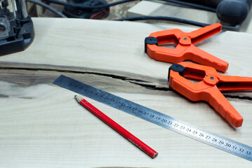 Clamps. Carpentry workshop. Carpentry clamps. Workplace. Ruler and pencil.