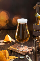 A glass of light tasty beer on a wooden pub table. Organic products