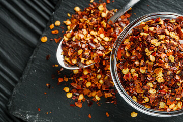 spicy chili flakes on a dark stone background