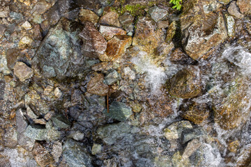 the mountain river flows quickly over the stones