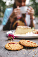 a girl drinks tea with cookies in a street cafe