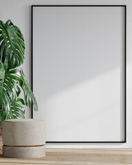 A vertical frame of a long tall vertical black frame for a photo or painting art. White plaster wall, beige velor pouf and large monstera palm. Scandinavian minimalist . Light interior. 3d rendering.