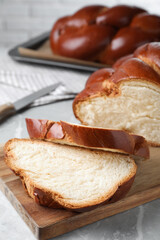 Cut homemade braided bread on grey table, closeup. Traditional Shabbat challah