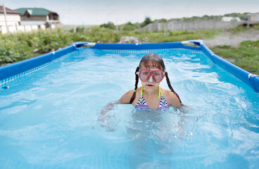 Girl child bathes in the pool