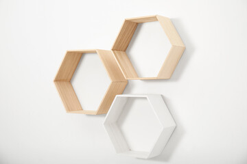 Empty honeycomb shaped shelves on white wall