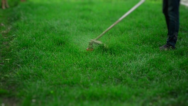 Cutting grass with trimmer in slow motion. 500 fps. Shallow depth of field