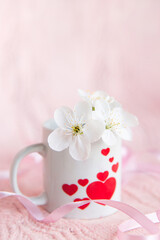 Obraz na płótnie Canvas valentine's day concept. white cup for coffee with hearts on a pale pink background 