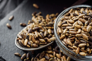 milk thistle seeds on a black wooden rustic background