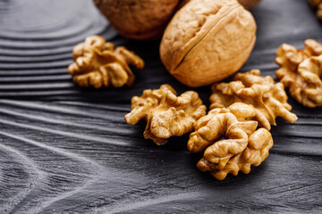 dried walnuts on a black rustic wooden background