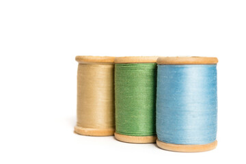 Multi-colored spools of thread close-up. Multicolored sewing threads on an isolated white background	
