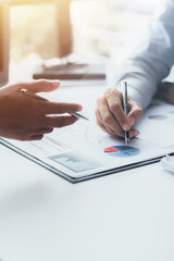Two businessmen pointed to the material for the meeting, working together to plan to develop and solve common business problems. Concept of business management for growth and quality.