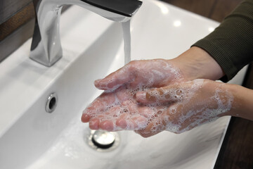 Fototapeta premium Woman washing hands in sink, closeup view