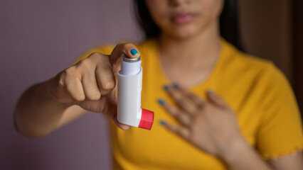 Asthmatic patient catching inhaler having an asthma attack. Young woman having asthma, chronic...