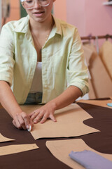 Woman cutting out pieces of clothing in a sewing workshop