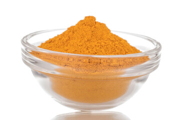 Aromatic bright yellow spice turmeric in a glass dish, close-up, isolated on a white background.