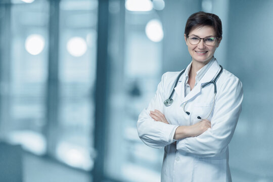 Woman doctor smiling with arms crossed .