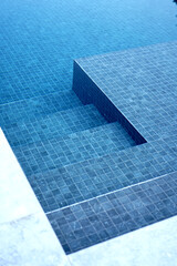 A swimming pool stairs with clear beautiful water.