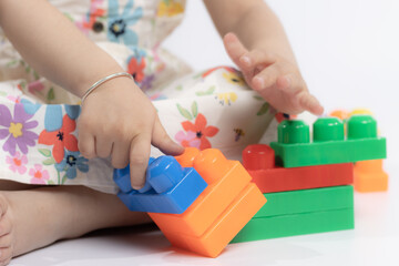 Close up of kids's hands playing with colorful building blocks connector toys on the floor. Educational toys for preschool kindergarten child. Fun, Activity, Learning, School, Nursery, Daycare Concept