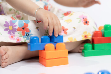 kids's hands Close up of playing with colorful building blocks connector toys on the floor. Educational toys for preschool kindergarten child. Fun, Activity, Learning, School, Nursery, Daycare Concept