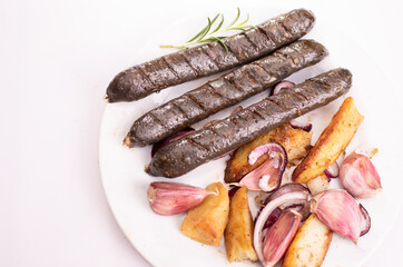 Grilled, roasted vegan, vegetarian sausages on a plate, isolated. Composition with buckwheat blood sausages.