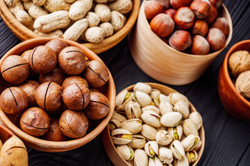 set of different nuts on a black rustic wooden background