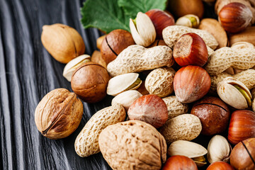 set of different nuts on a black rustic wooden background