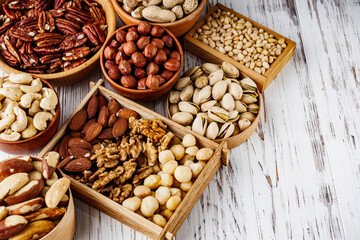 set of different nuts on a white wooden rustic background