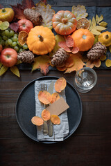 Autumn table place setting with drying leaves and pumpkins. Happy Thanksgiving Day. Vertical. Top view.