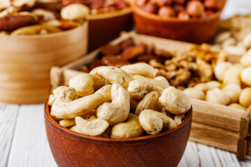 set of different nuts on a white wooden rustic background