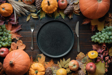 Autumn table place setting with drying leaves and pumpkins. View from above. Happy Thanksgiving Day.