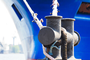 Moored blue ship in marina. Ship moorings bollard close-up