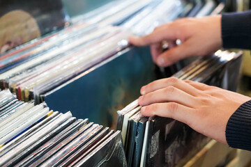 People hands choosing vinyl record in music record shop. Music addict concept. Old school classic concept