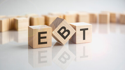 EBT - Earnings Before Taxes shot form on wooden block