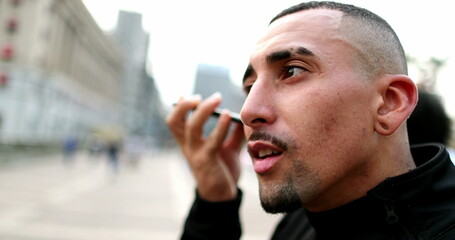 Hispanic man talking on smartphone in conversation in downtown city