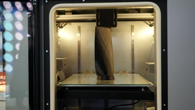 Automated technical 3d printer. Media. 3D printer creates tall object. Large automated 3d printer