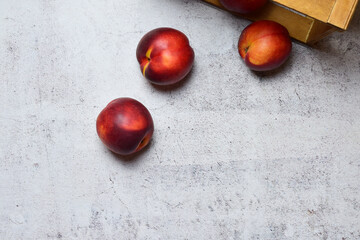 Zenith view, fruit, nectarine on stone background and wooden box, copy space.