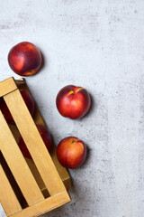 Overhead view, fruit, nectarine on stone background and wooden box, copy space.