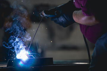 Industry worker welding iron pieces at work - obrazy, fototapety, plakaty