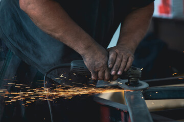 Close up on a man held an angle grinder to cut an iron with sparks